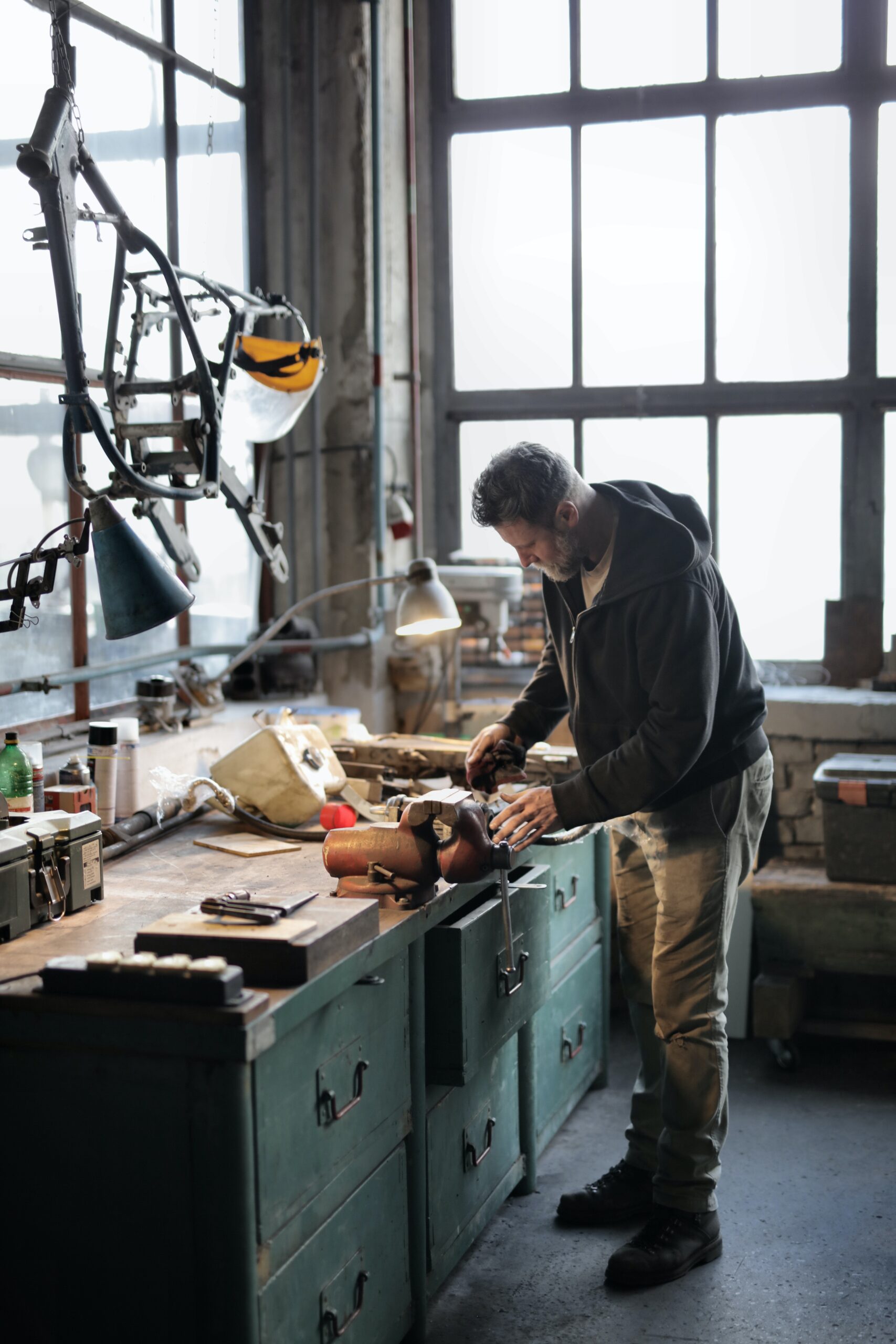 Man working in his workshop with various tools around him.